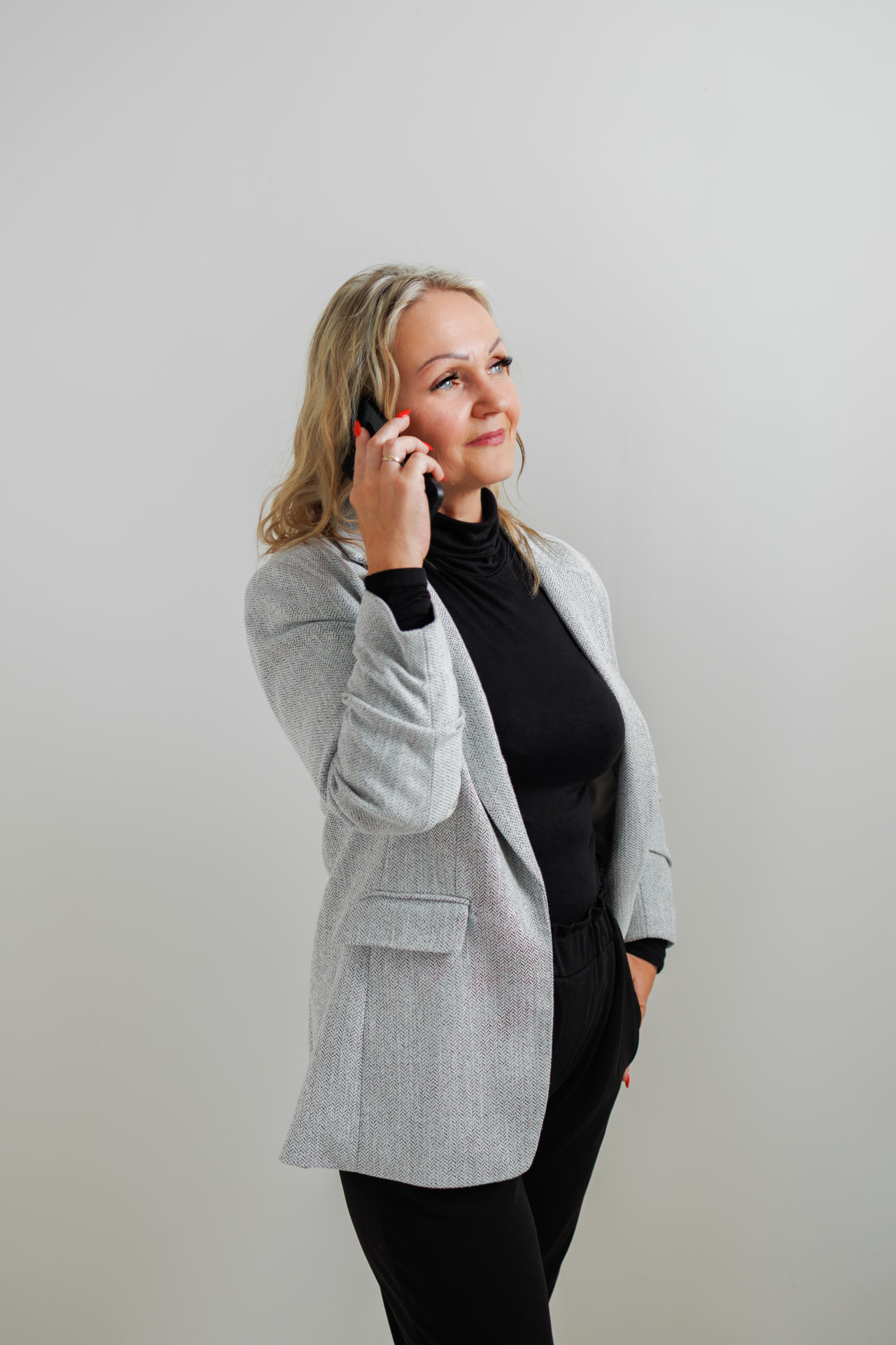Mariola Garbacz steht mit einem Telefon in der Hand als persönliche Ansprechpartnerin bereit